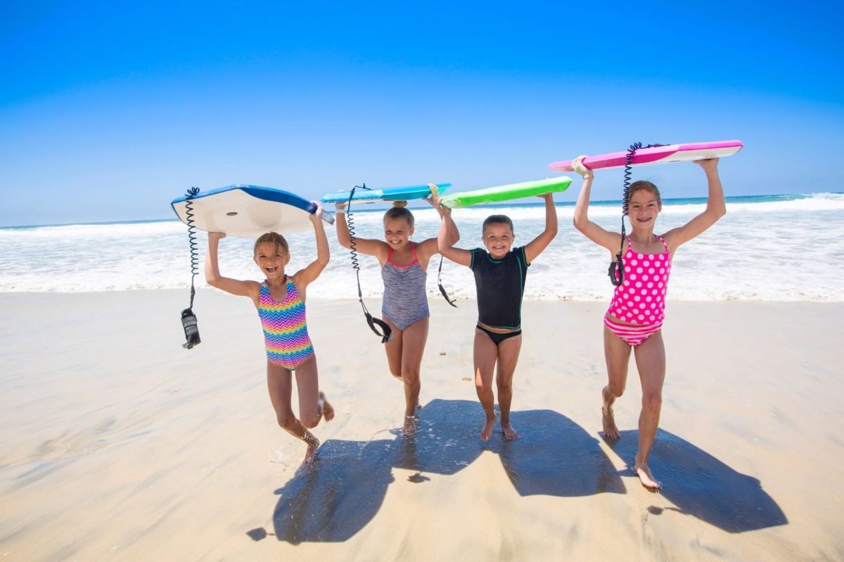 kids boogie boarding on the beach