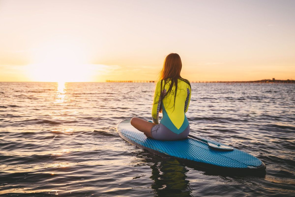 woman on a paddleboard at sunset